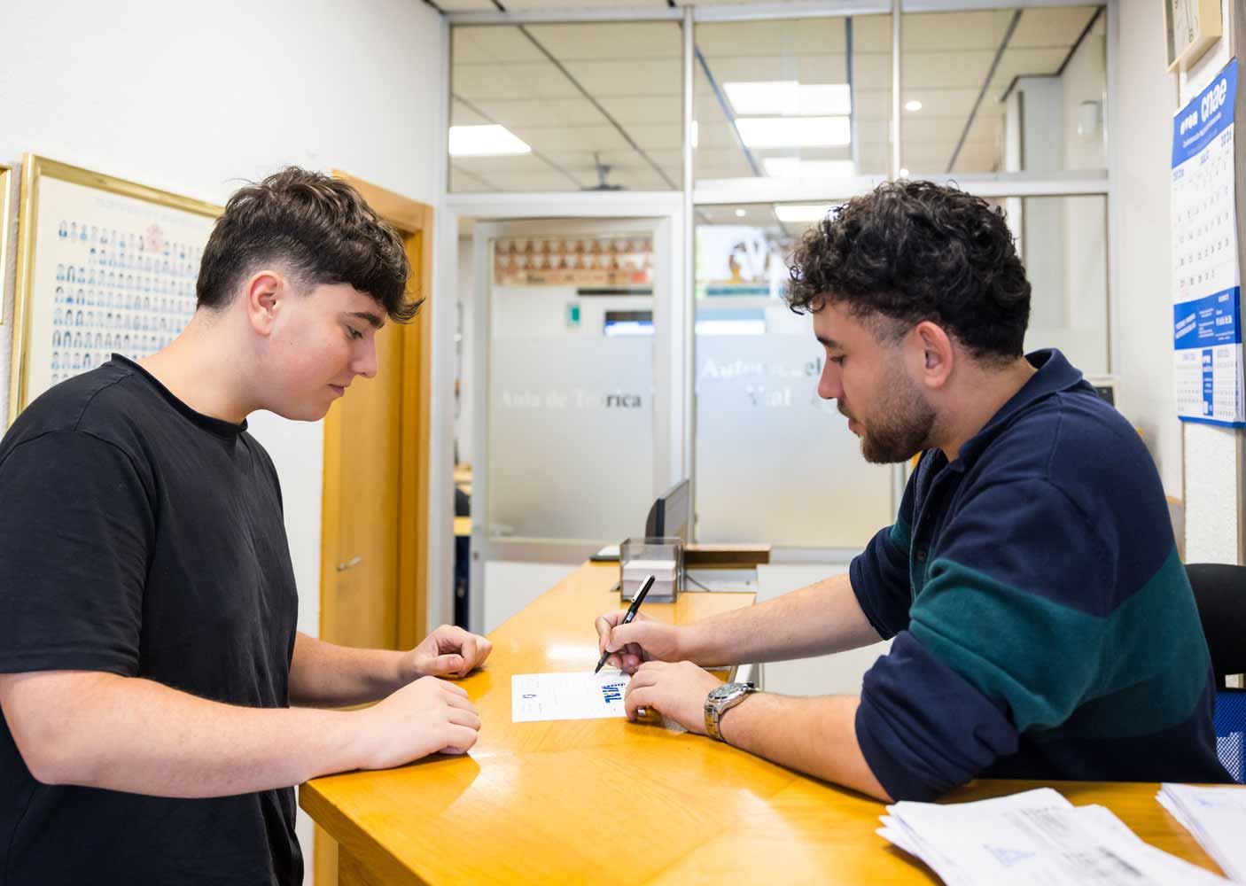 Alumno formalizando su matrícula en el mostrador de Autoescuela Vial en Logroño