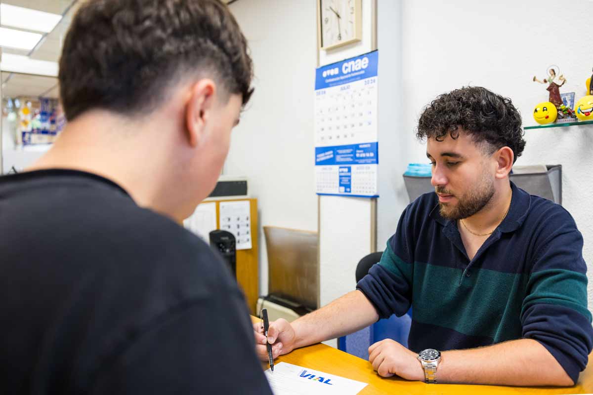 Trabajador de Autoescuela Vial cumplimentando la documentación de un alumno