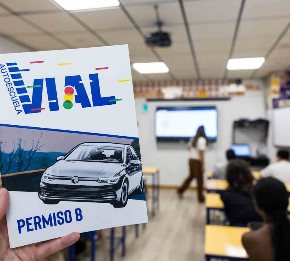 Manual del permiso B de Autoescuela Vial sostenido en el aula de teórica